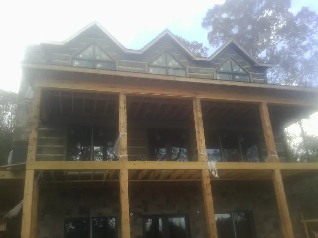 Dormers and porch framing on a large log home under construction — Roof Coating work by our crew in Netcong