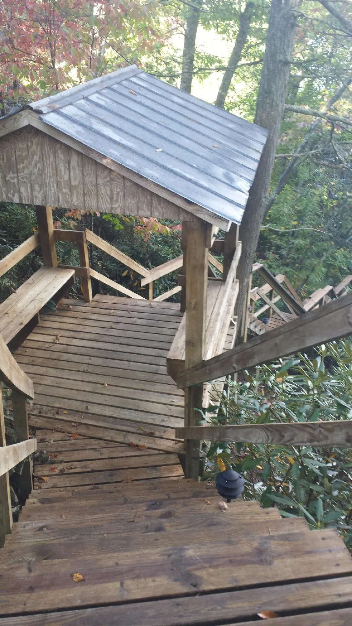 Metal roofed shelter over wooden steps on a wooded walkway — Skylight Repair & Installation work by our crew in Netcong